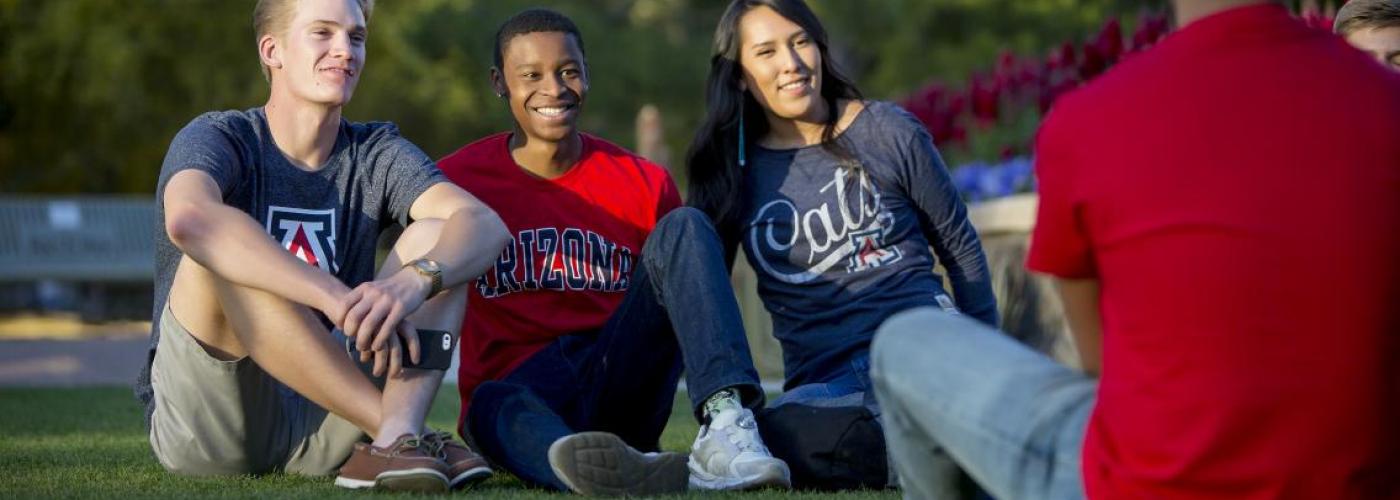 Three UA students sitting on grass